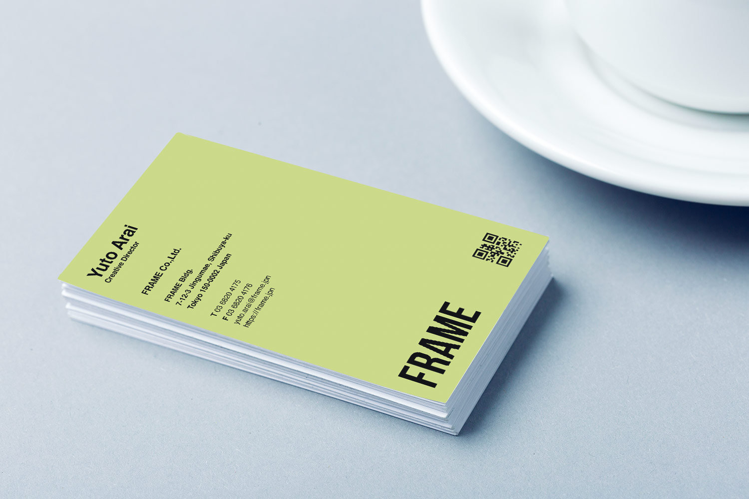 ぼかした背景の中で差し出された名刺のイメージ写真(クリエイティブな印象を伝えるためのビジュアル)