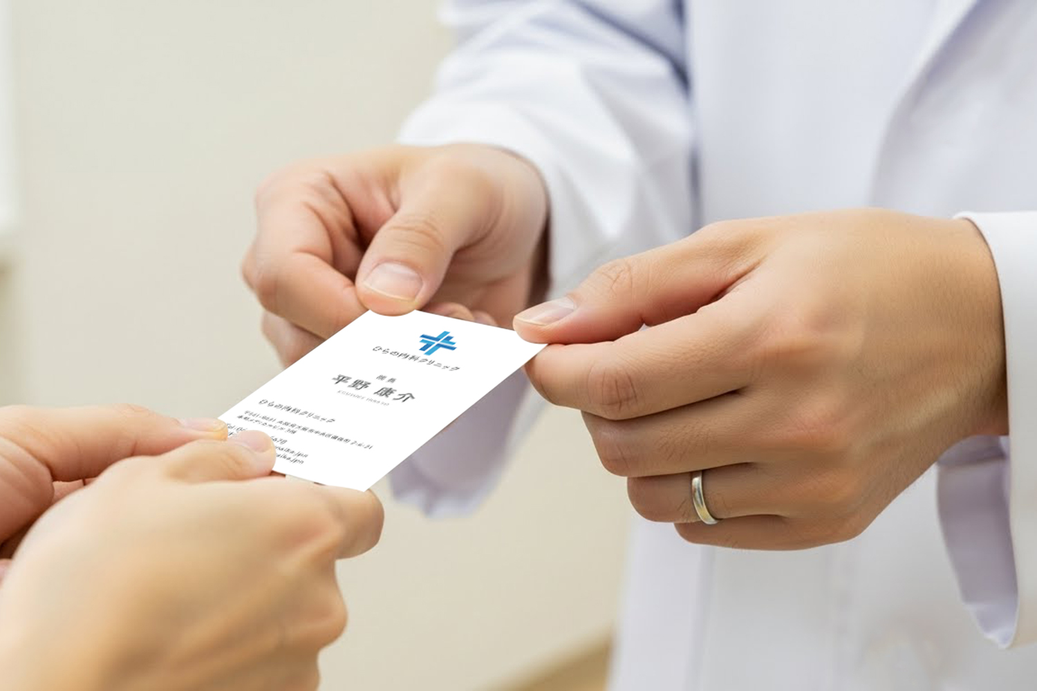 医師が患者へひらの内科クリニック名刺を手渡す場面の写真。名刺の使用シーンがわかるイメージカット