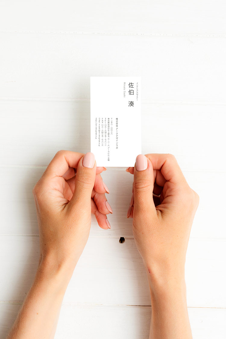インテリアデザイナー名刺の表面を手に持つイメージ写真｜縦組み文字と余白設計が美しい洗練されたミニマルデザイン