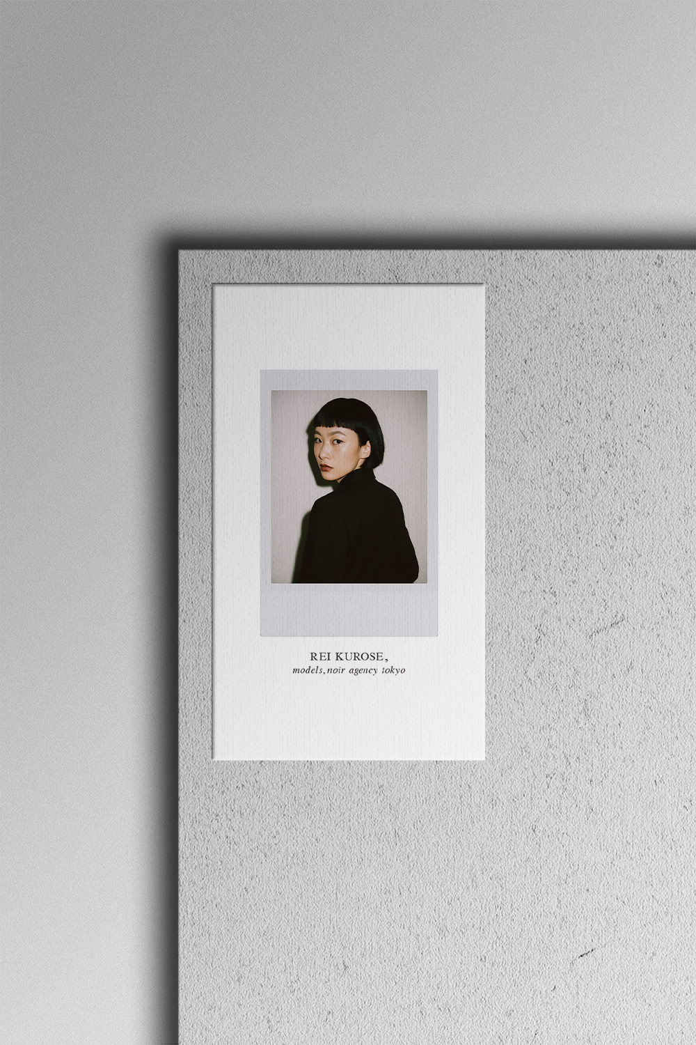 モデル名刺のモックアップ画像。紙の質感とポラロイド写真の雰囲気が伝わるミニマルデザインの名刺を表現したビジュアル