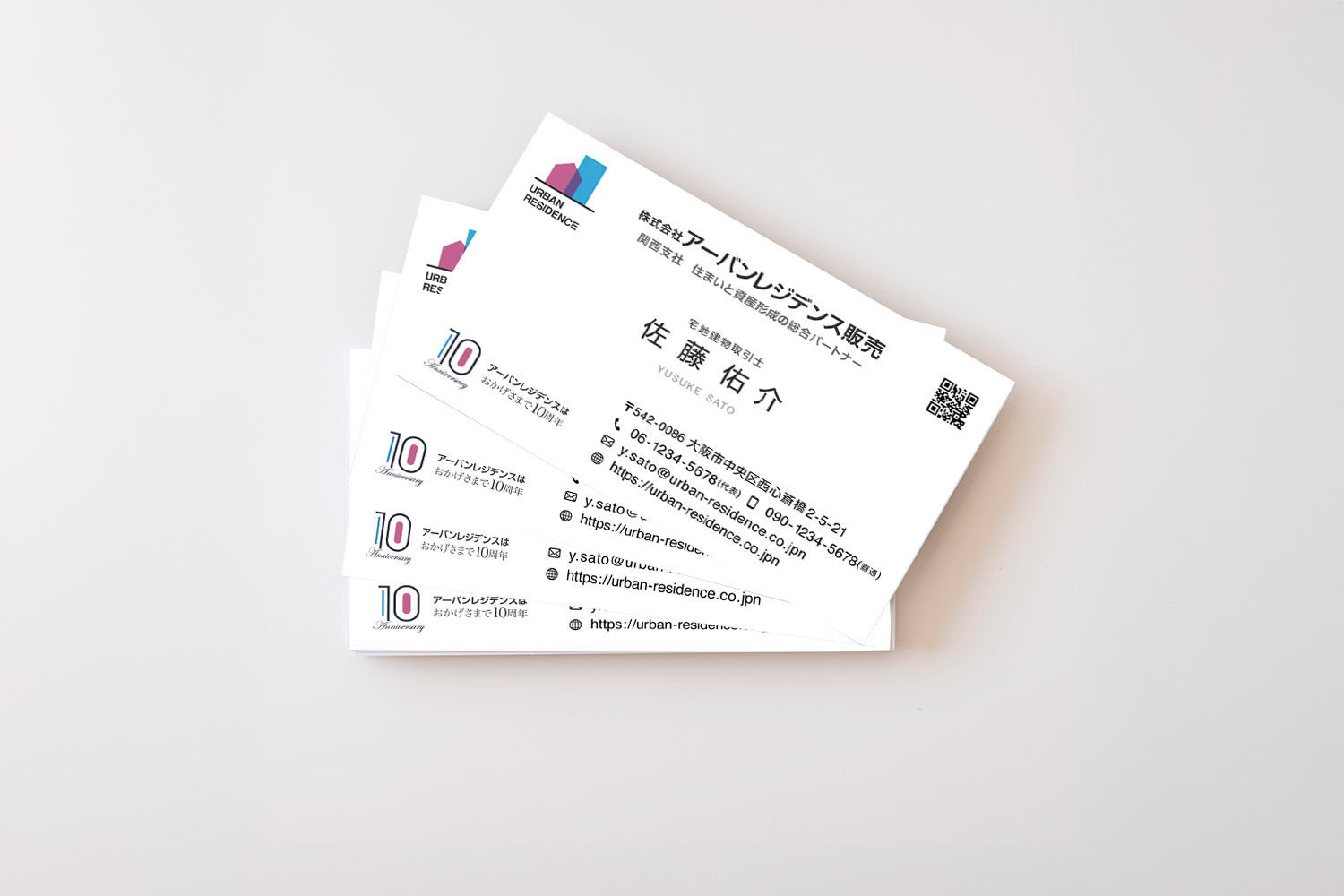 不動産企業向け名刺デザインの制作事例。複数枚を重ねた写真で上品なホワイト基調の印象。